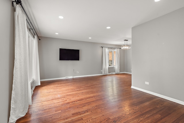 empty room with wood-type flooring and a barn door