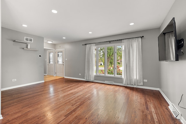 unfurnished living room with wood-type flooring