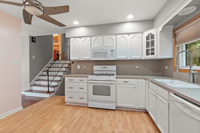 kitchen with white appliances, light hardwood / wood-style floors, white cabinetry, and sink