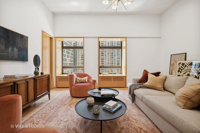 living room with light hardwood / wood-style flooring and a notable chandelier