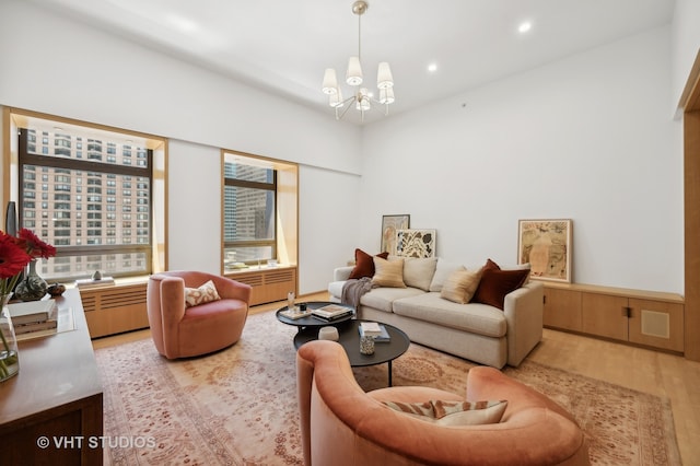 living room with light hardwood / wood-style flooring and an inviting chandelier