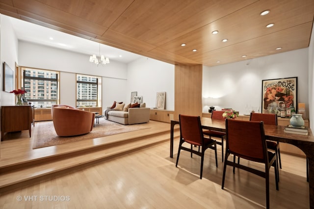 dining space featuring a chandelier, light hardwood / wood-style floors, and wooden ceiling