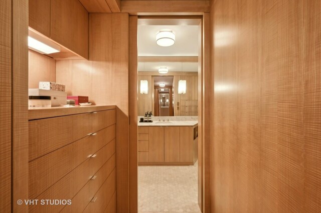 corridor featuring wood walls and sink