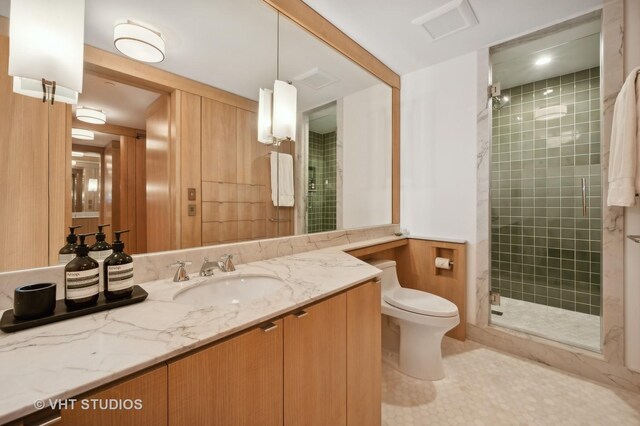 bathroom featuring vanity, toilet, and a shower with door