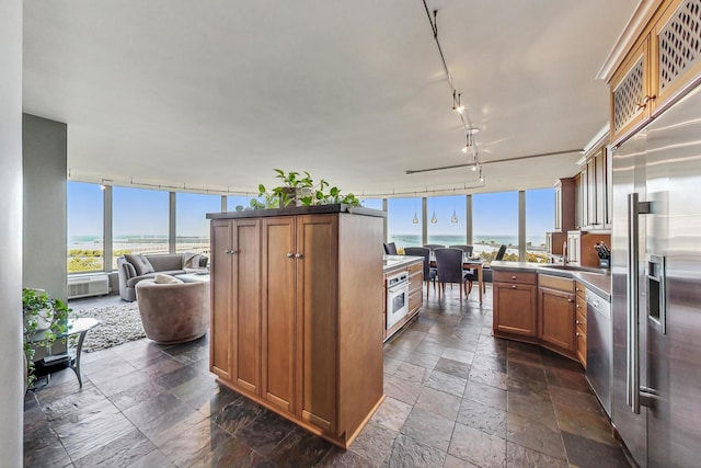 kitchen with stainless steel appliances, a water view, and rail lighting