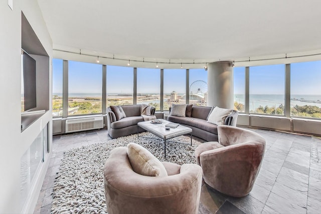 living room featuring rail lighting, a water view, and a wealth of natural light