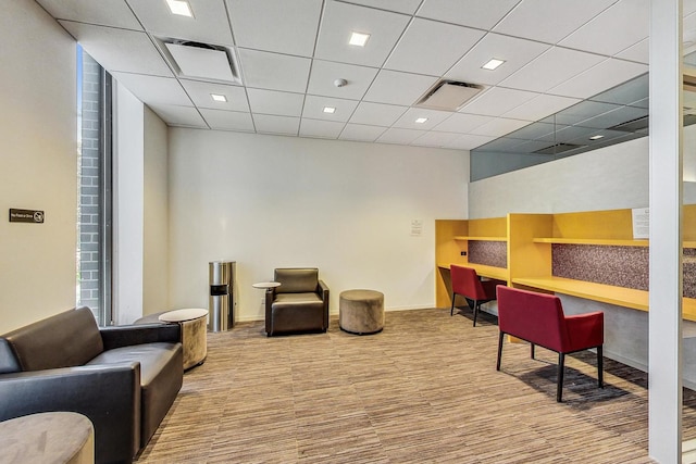 carpeted home office with a drop ceiling