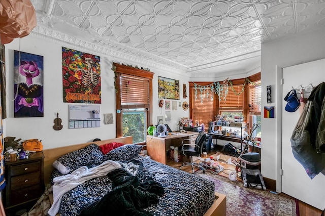 bedroom with crown molding and hardwood / wood-style floors