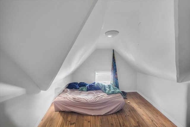 bedroom featuring hardwood / wood-style floors and vaulted ceiling