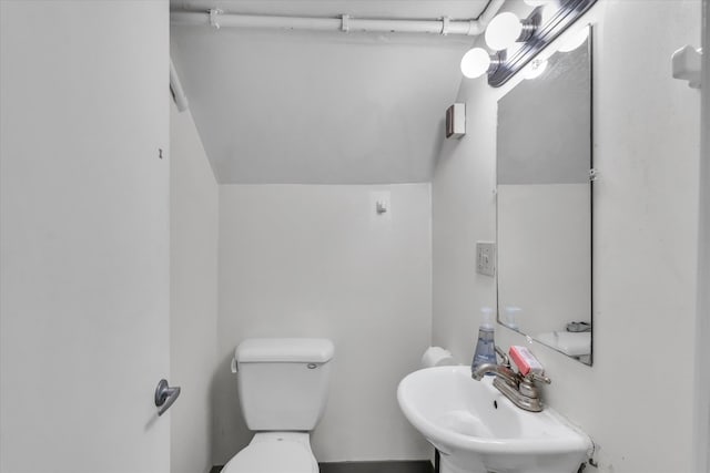 bathroom featuring lofted ceiling, sink, and toilet