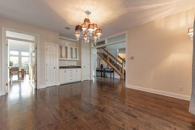 unfurnished dining area featuring dark wood-type flooring and a notable chandelier