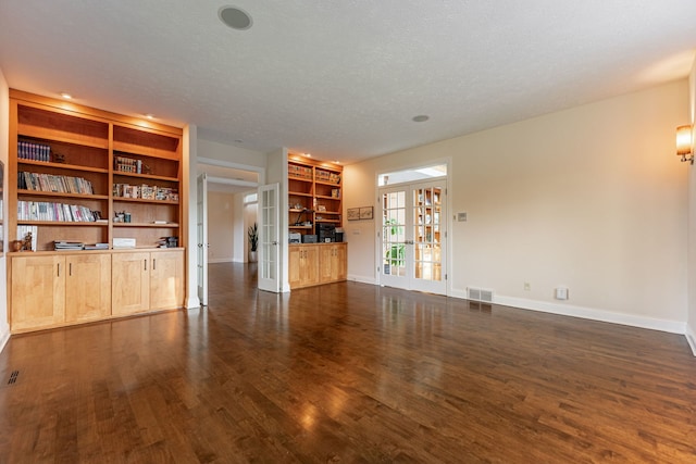 unfurnished living room with french doors, a textured ceiling, and dark hardwood / wood-style floors