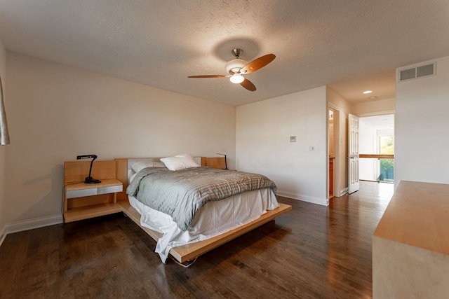 bedroom with a textured ceiling, ceiling fan, and dark hardwood / wood-style flooring