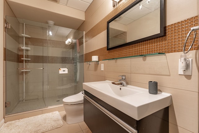 bathroom with tile walls, tile patterned flooring, vanity, and toilet