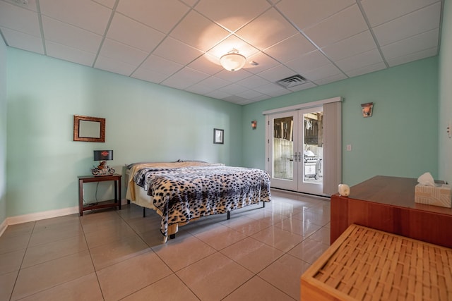 tiled bedroom with access to outside, french doors, and a paneled ceiling