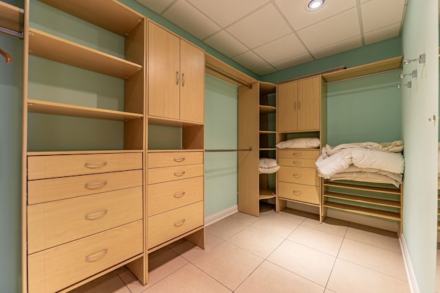 walk in closet with a paneled ceiling and light tile patterned floors