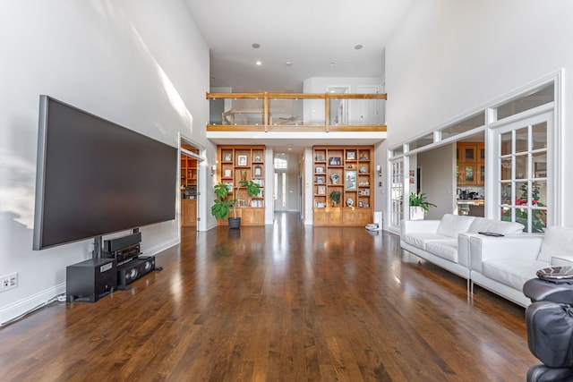 unfurnished living room with hardwood / wood-style floors and a high ceiling