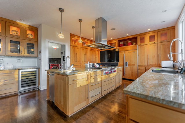 kitchen featuring a kitchen island with sink, beverage cooler, island range hood, appliances with stainless steel finishes, and light stone countertops