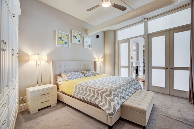 bedroom featuring ceiling fan, light colored carpet, and french doors