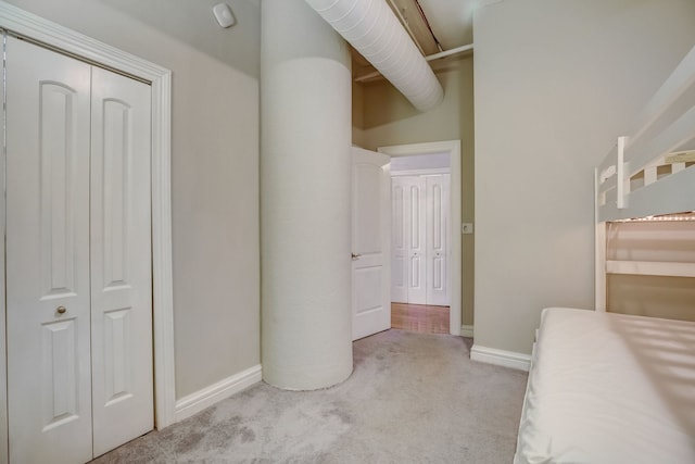 unfurnished bedroom with light colored carpet and a closet