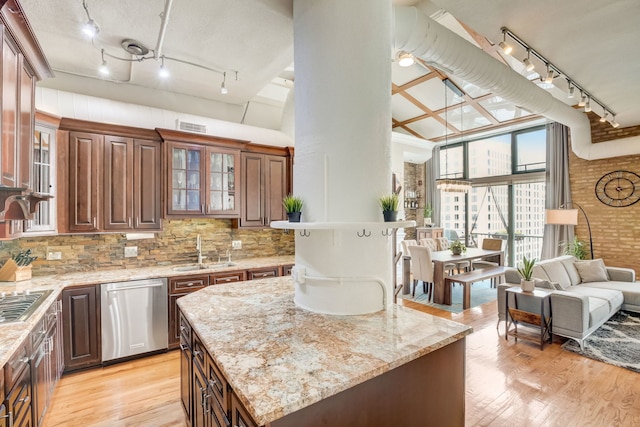 kitchen featuring appliances with stainless steel finishes, light wood-type flooring, and decorative backsplash