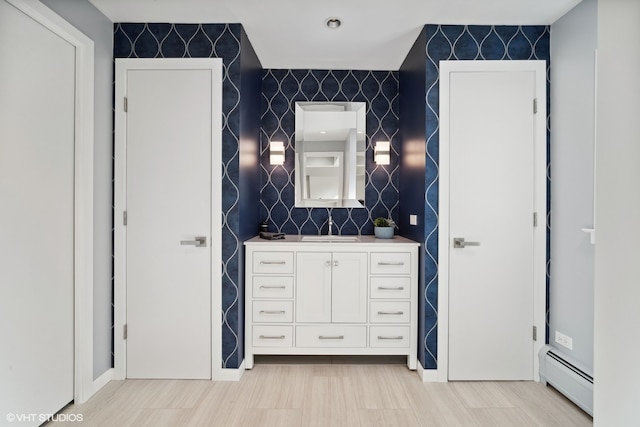 bathroom with tile walls, baseboard heating, and vanity