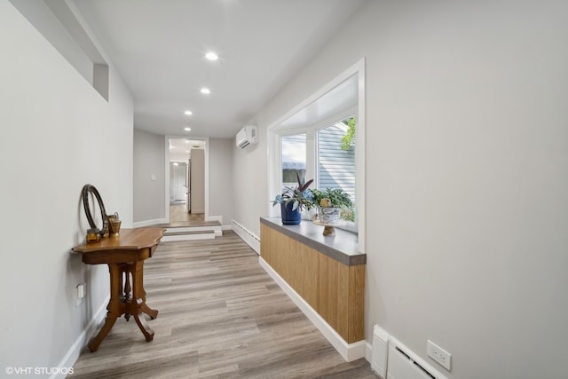 corridor featuring a baseboard radiator, light wood-type flooring, and a wall mounted air conditioner