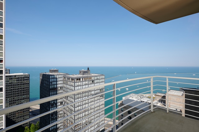 balcony featuring central air condition unit and a water view