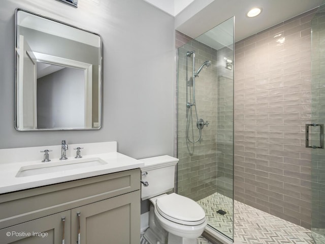 bathroom featuring vanity, toilet, and a shower with door