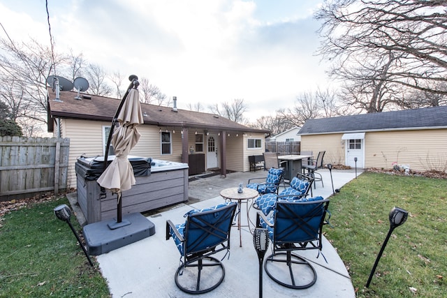 back of house featuring a hot tub, a patio area, and a yard