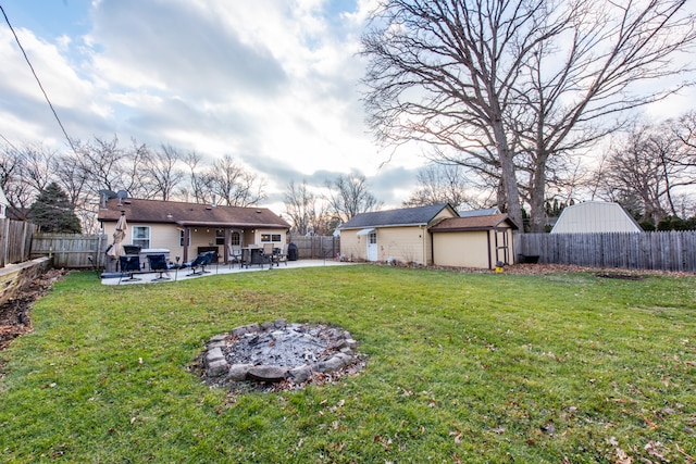 view of yard with a fire pit, a patio, and a storage unit