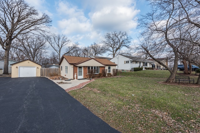 view of front of home with a front yard, a garage, and an outdoor structure