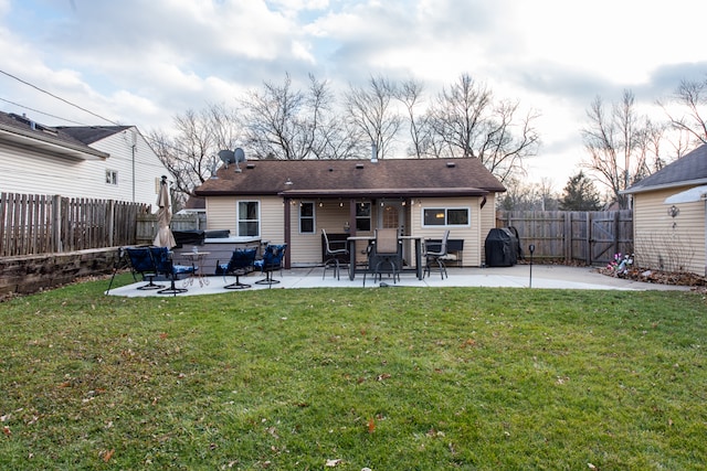 rear view of property featuring a lawn and a patio