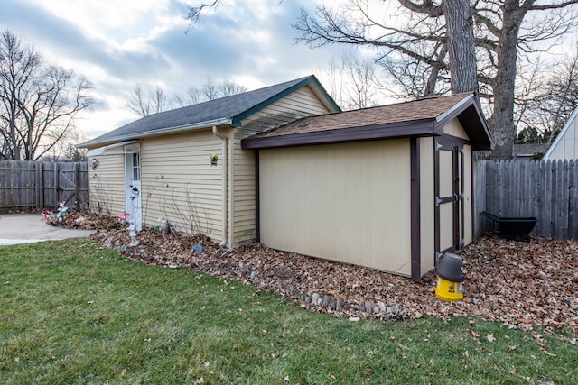 view of side of property featuring a shed and a yard