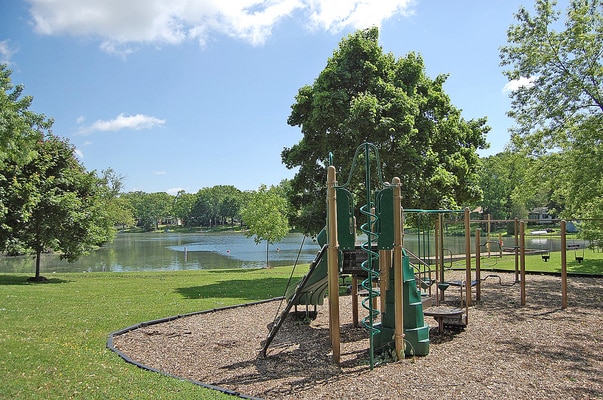 view of jungle gym with a lawn and a water view