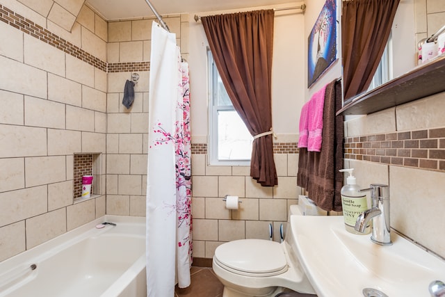 full bathroom featuring shower / tub combo, tile walls, toilet, and sink