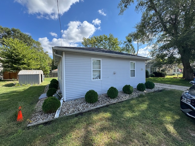 view of home's exterior with a storage shed and a lawn