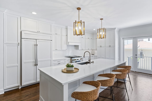 kitchen with pendant lighting, a kitchen island with sink, dark wood-type flooring, and white cabinetry