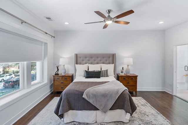 bedroom featuring dark hardwood / wood-style flooring, ceiling fan, and ensuite bath