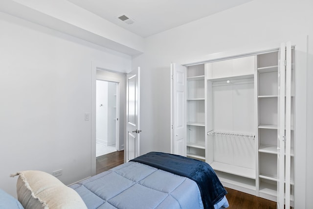 bedroom with dark wood-type flooring and a closet