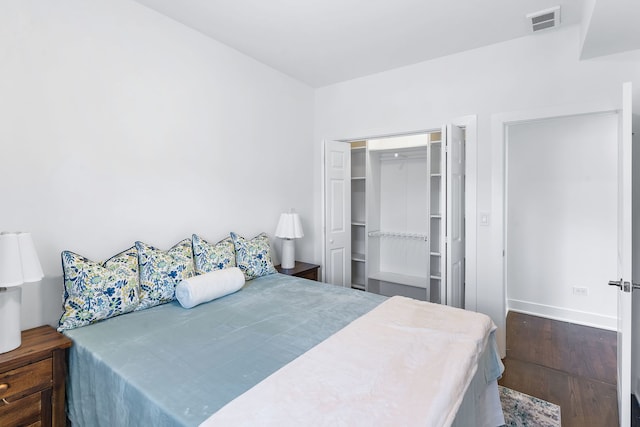 bedroom with a closet and dark hardwood / wood-style floors