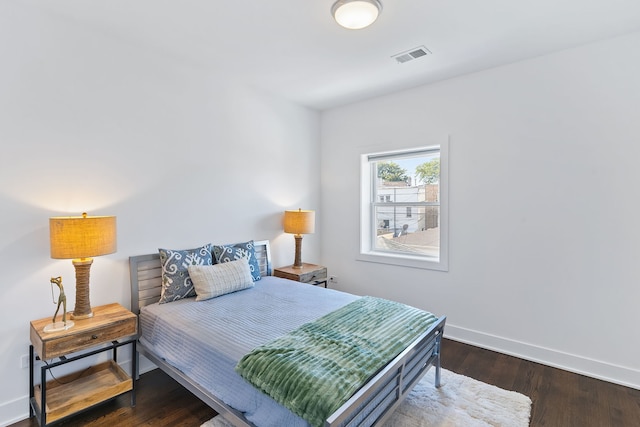 bedroom with dark wood-type flooring