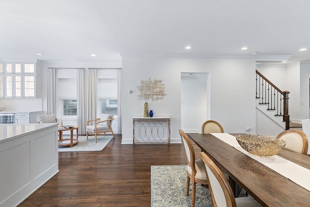 dining area with dark wood-type flooring and crown molding