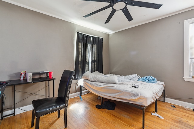 bedroom featuring ornamental molding, light wood-type flooring, and ceiling fan