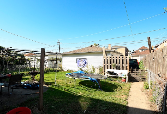 view of yard with a trampoline and a patio area