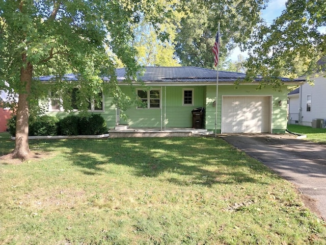 ranch-style house with aphalt driveway, metal roof, a front lawn, and an attached garage