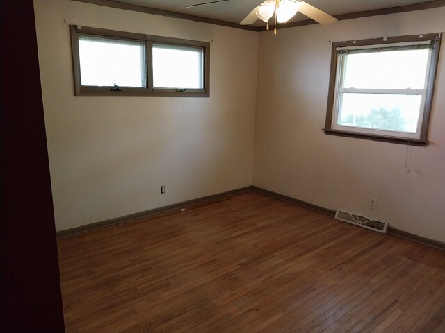 unfurnished room featuring crown molding, dark hardwood / wood-style floors, and ceiling fan