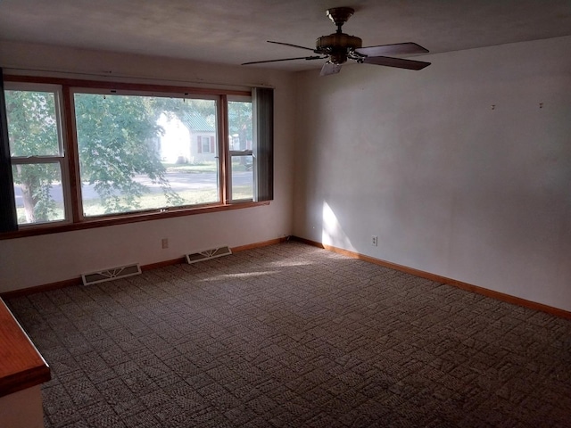 empty room featuring visible vents, ceiling fan, carpet flooring, and baseboards