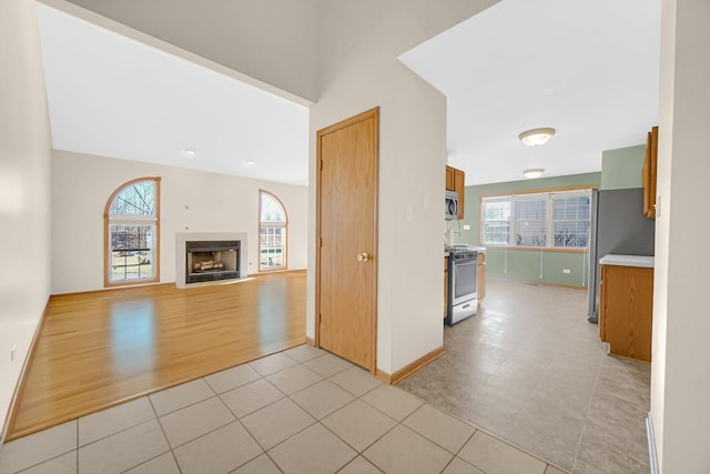 unfurnished living room with light tile patterned floors and plenty of natural light