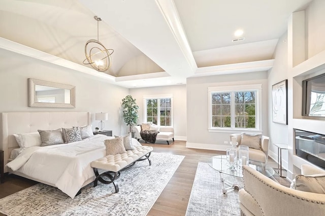 bedroom featuring light hardwood / wood-style flooring, multiple windows, and an inviting chandelier